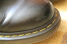 Distinctive yellow stitching on Doc Martens shoes.